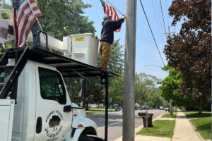 employee installing town flags